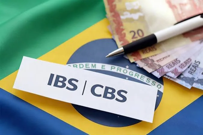 Cartão com as siglas IBS e CBS sobre a bandeira do Brasil e notas de dinheiro